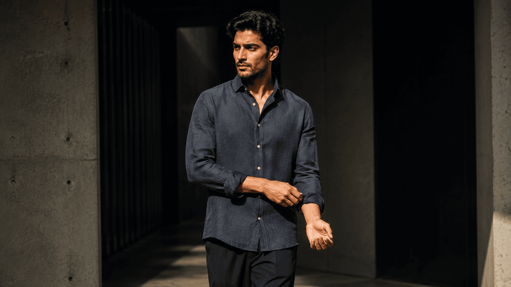 Navy linen shirt on a model in a dark concrete corridor