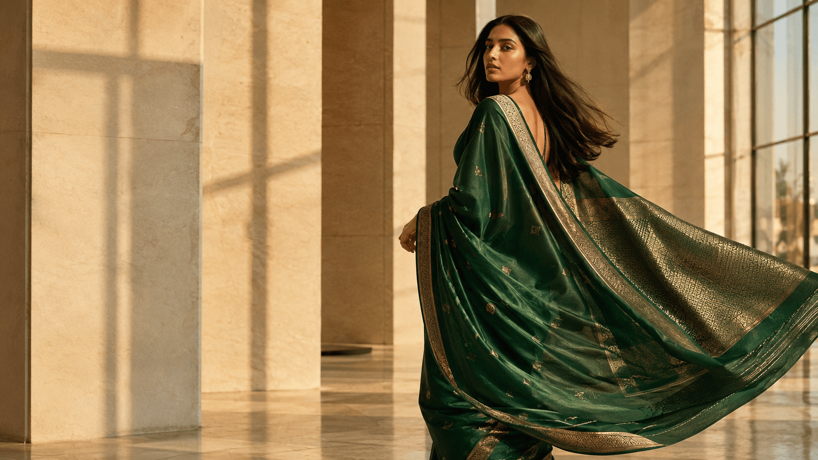 Emerald silk saree photographed on a model in a sunlit stone hall